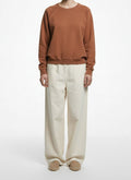 Full body view of the model wearing The Great. Terracotta Cotton Raglan Sweatshirt Size 1